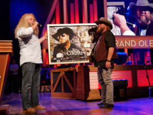 Jamey Johnson Surprises Colt Ford at the Grand Ole Opry with RIAA Award 