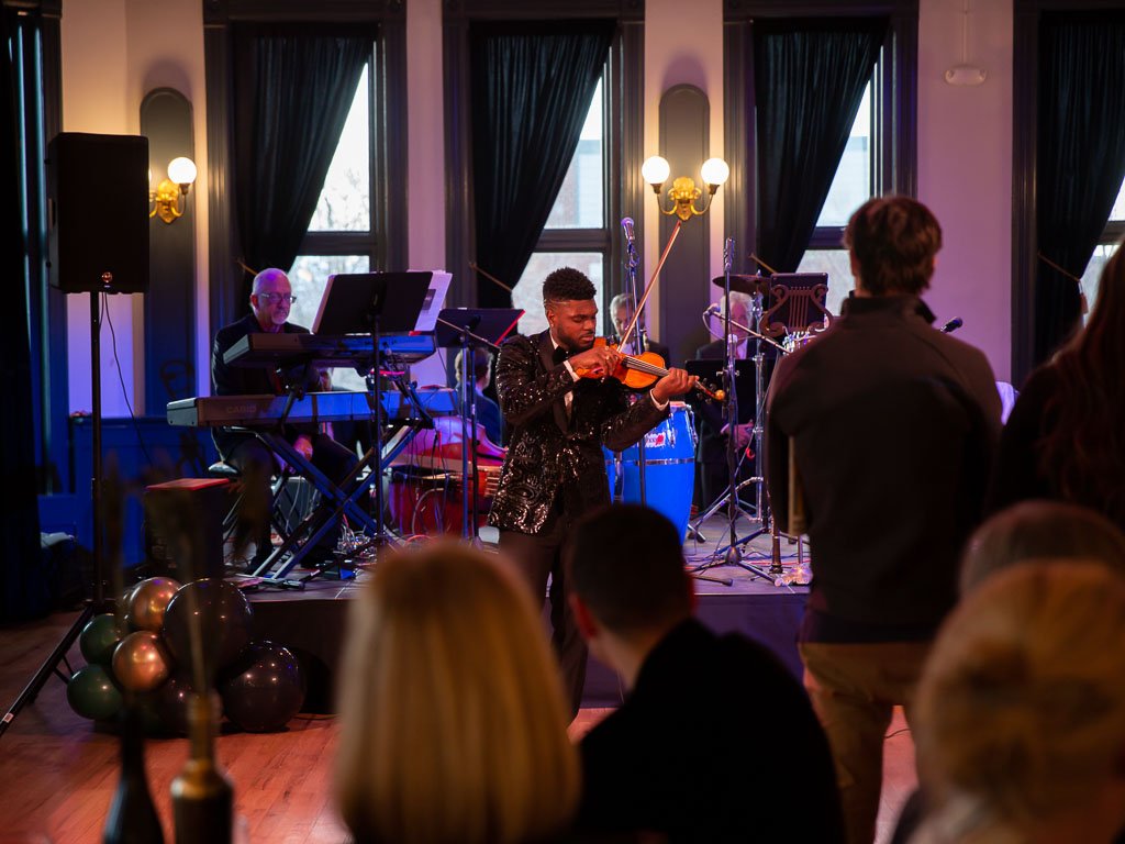 Edward W. Hardy performing in front of a crowd at El Sistema Colorado's 2023 Gala event at the Savoy Denver.