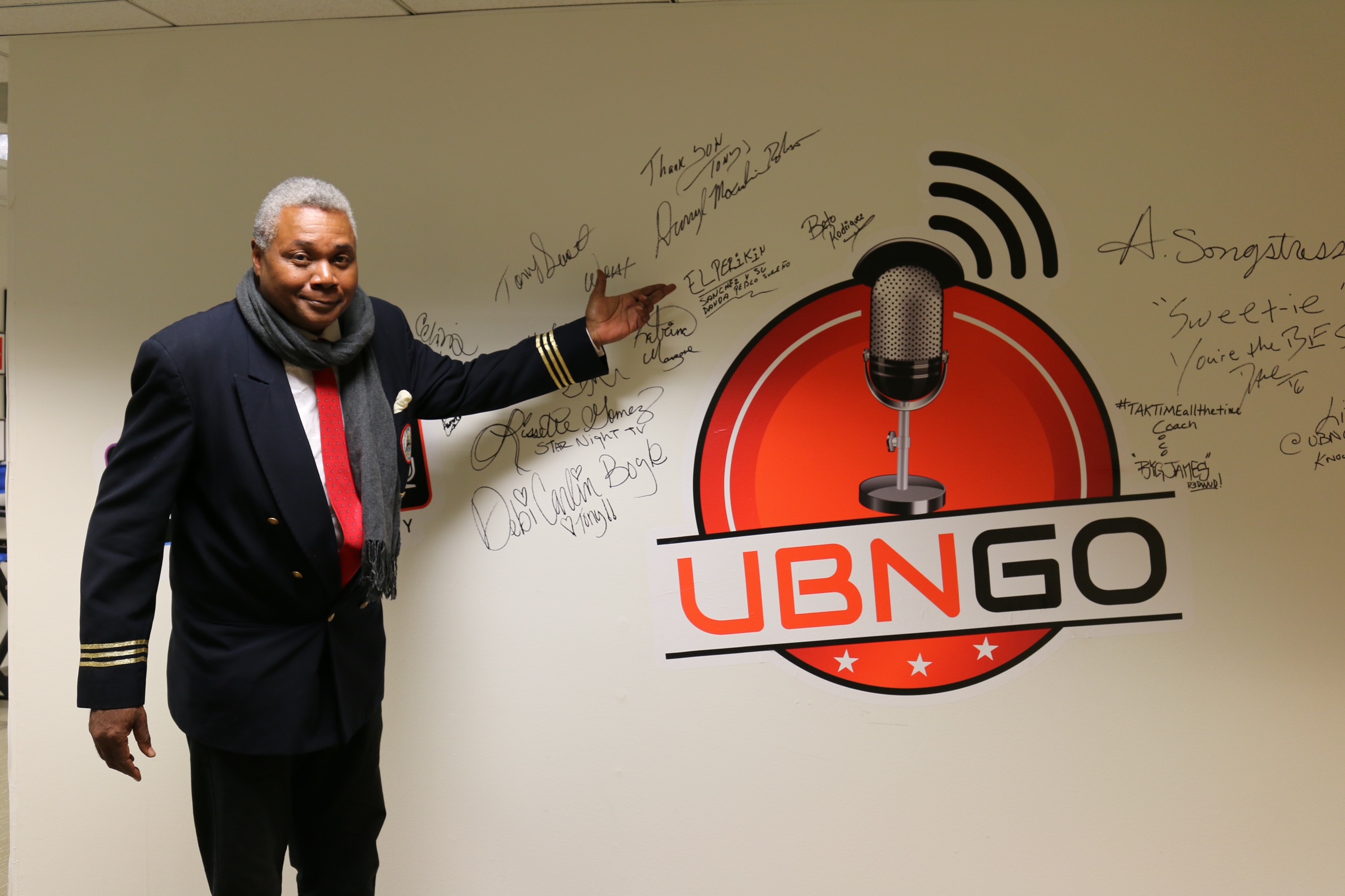 After completing his appearance on the April 18, 2022 edition of Ron Brewington's 'The Actor's Choice,' Darryl Maximilian Robinson, at the invitation of UBNGO chief engineer Tony , was delighted to sign the wall depicting the studio's festive logo. Photo by J.L. Watt.