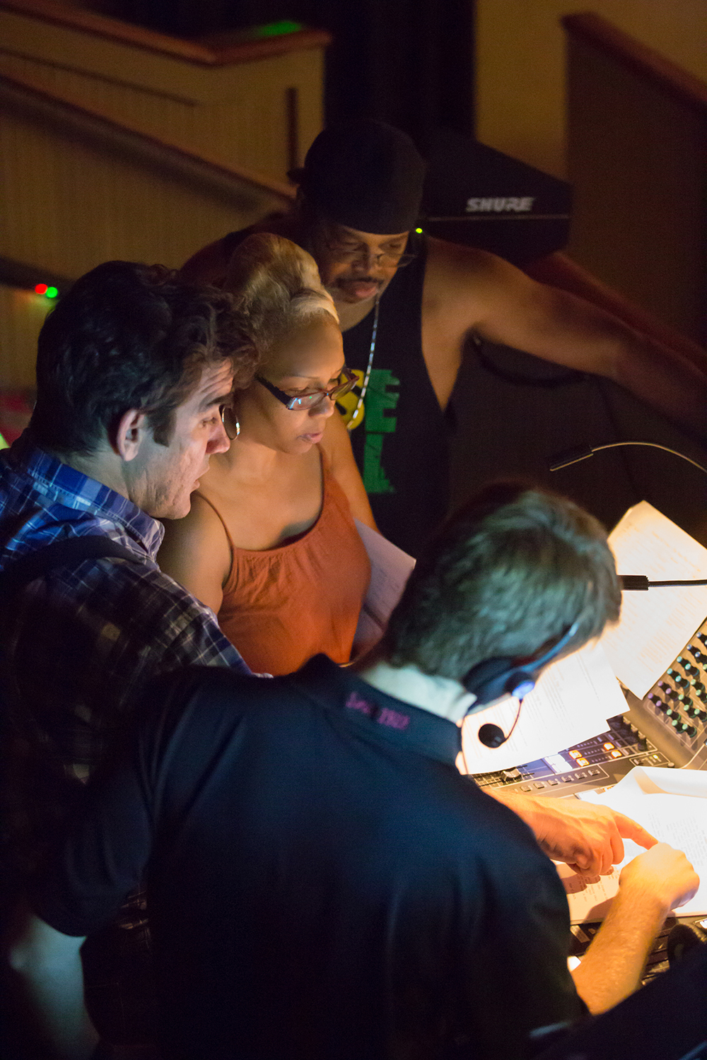 Writer, producer, and director Ceola J. and theatre director Joel Roster, and music composer Dre Griffin with theatre sound technician review script during filming.