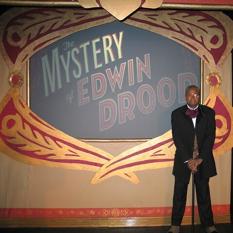 It Is A Novel Unsolved: Darryl Maximilian Robinson starred as The Chairman Mr. William Cartwright in the 2018 revival of The Mystery of Edwin Drood at St. Bonaventure Church in The Windy City.