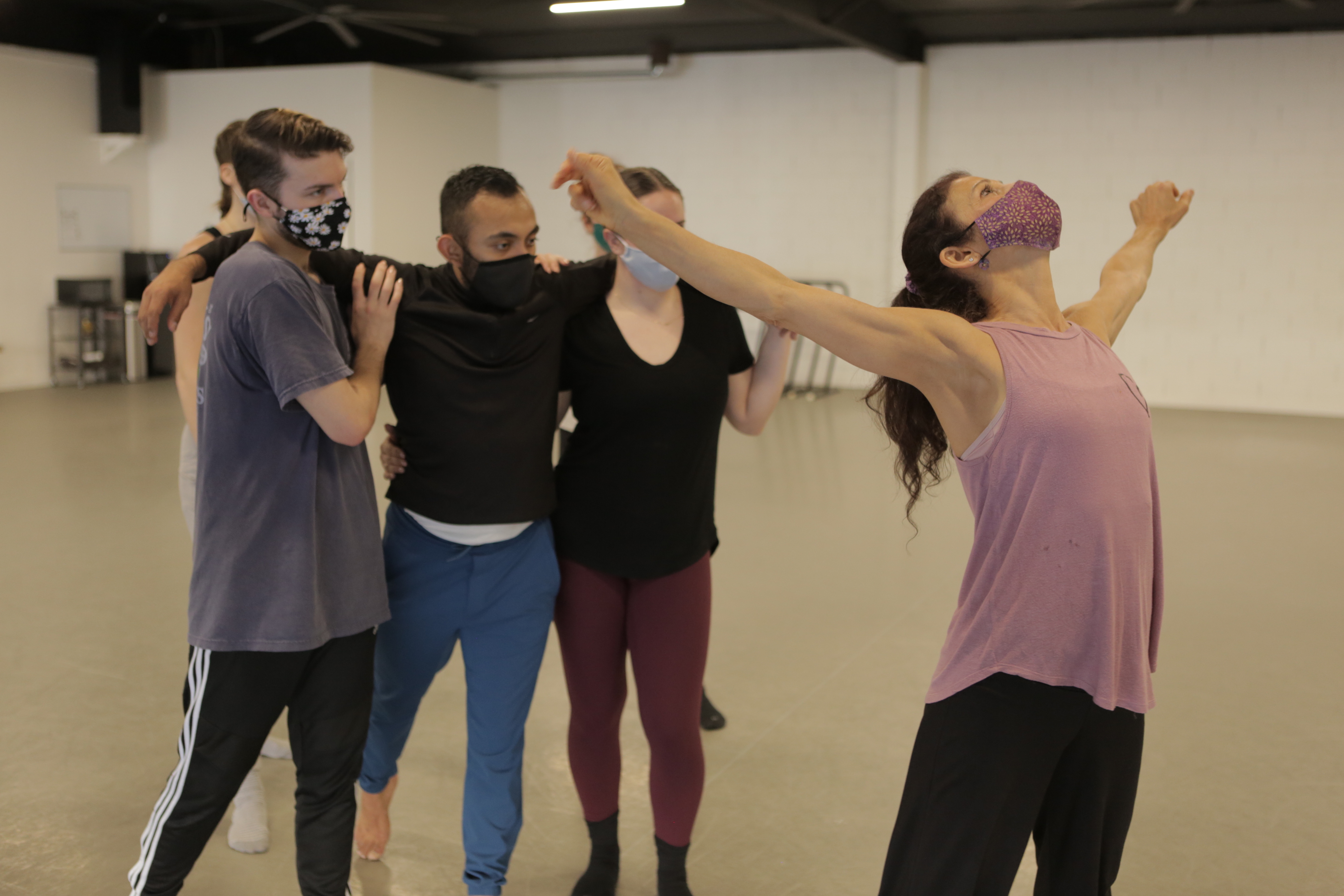 In-studio rehearsal photo of sjDANCEco Co-Artistic Director Maria Basile (in pink shirt) demonstrating movement from Yield to her dancers. Dancers (left to right) are: Ryan Tucker, Kevin Gaytan and Kyleigh Carlson. Photo by Tom Hassing courtesy of sjDANCEco.