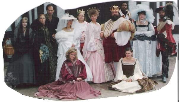 EXCALIBER SHAKESPEARE COMPANY OF CHICAGO FOUNDER DARRYL MAXIMILIAN ROBINSON SHARES A 1980S THEATRICAL MEMORY THAT'S STAINED WITH A LITTLE BLOOD!
HOW CLOSE IS A KILLER TO THE CROWN?: Behold the Royal Court of Barbara Burinski as Her Majesty, Queen Katherine and Ray Nelson as His Majesty, King Richard ( poised in their regal robes at center ). A VERY HAPPY COUPLE, NO QUESTION! But who near them is capable of MURDER, AND MURDER MOST FOUL AT A ROYAL WEDDING? Is it one of the Borgias' Royal Party from Italy ( on the far left ), capable of deadly swordplay and / or poisoning in an instant? Is it their extremely loyal Lord Chancellor, Sir Percival Degage', played by Richard D. Weber ( on the far right ) who, with satin or silk, is willing to kill with ease over the slightest fashion violation? Or is it someone even closer to The Crown. Standing beside the Queen is her younger sister, Princess Marigold of Lincolnshire, the scheduled bride, who may or may not be entirely pleased with the man near her, and scheduled groom, the Prince of France. Behind the right of the King is Darryl Maximilian Robinson as His Eminence, Tomas de Torquemada, The Grand Inquisitor of Spain, who has some serious experience conducting an investigation ( but due to his own nefarious and notorious reputation as The Presiding High Official of The Church for The Spanish Inquisition ) finds he too is a Suspect! Everyone here is CAPABLE OF MURDER. And only Visitors and Guests To King Richard's Faire will ( By Their Votes! ) decide at each performance WHODUNIT in 