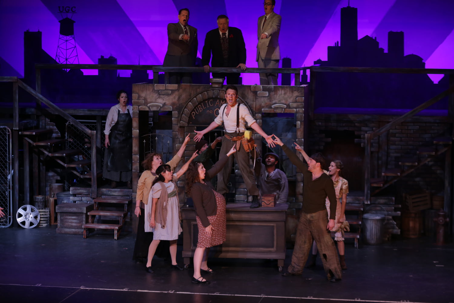 David Geinosky as Bobby Strong with the cast of Theatre Nebula's Urinetown, The Musical!