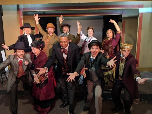 Damned, But There You Are!: Darryl Maximilian Robinson as The Chairman Mr. William Cartwright and Mayor Thomas Sapsea and Sarah Myers as Edwin Drood and Miss Alice Nutting ( at center ) lead the Principal Cast Members in the opening number 'There You Are' in the 2018 Saint Sebastian Players of Chicago Revival of Rupert Holmes' 'The Mystery of Edwin Drood.' Photo by Eryn Walanka. 