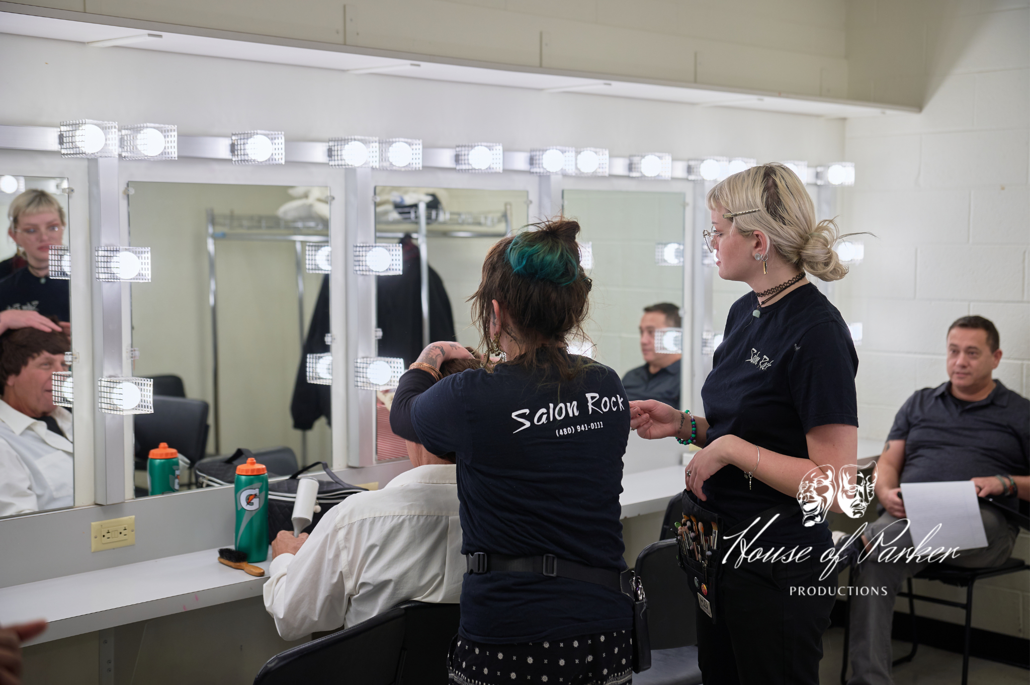 Joe Paul Garcia and Rick Howard in hair and makeup, highlighting the level of care, precision, and professional artistry dedicated to shaping each character before they take the stage.