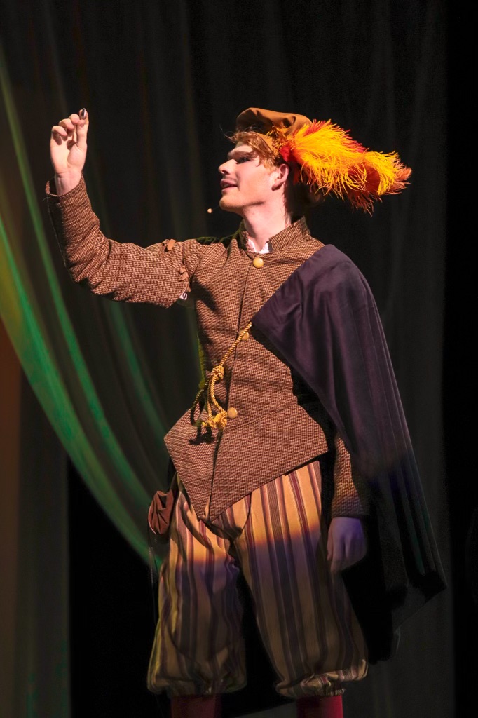 Rosencrantz (Jack Andersen) observes a coin.