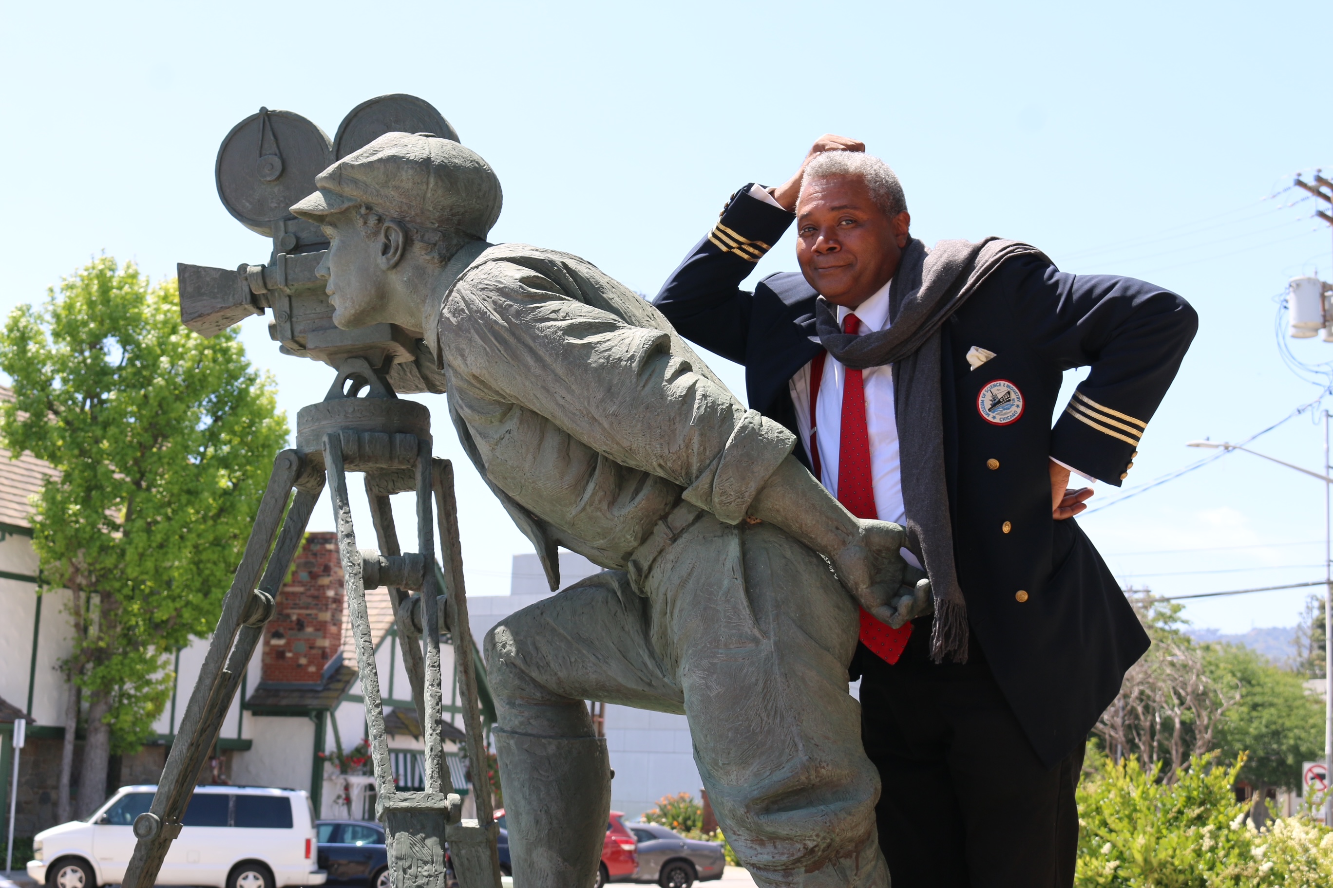 Making The Shot: Across the street from Warner Bros. Studios in Burbank, CA., stage actor and play director Darryl Maximilian Robinson ponders the impressive statue of a determined cameraman.