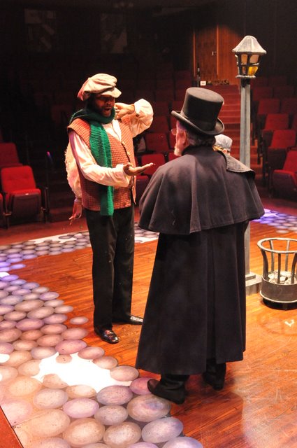 Payment Due Upon Delivery: Darryl Maximilian Robinson as The Poultry Man and Mario Di Gregorio as Ebenezer Scrooge in the 2010 Glendale Centre Theatre musical staging of A Christmas Carol.