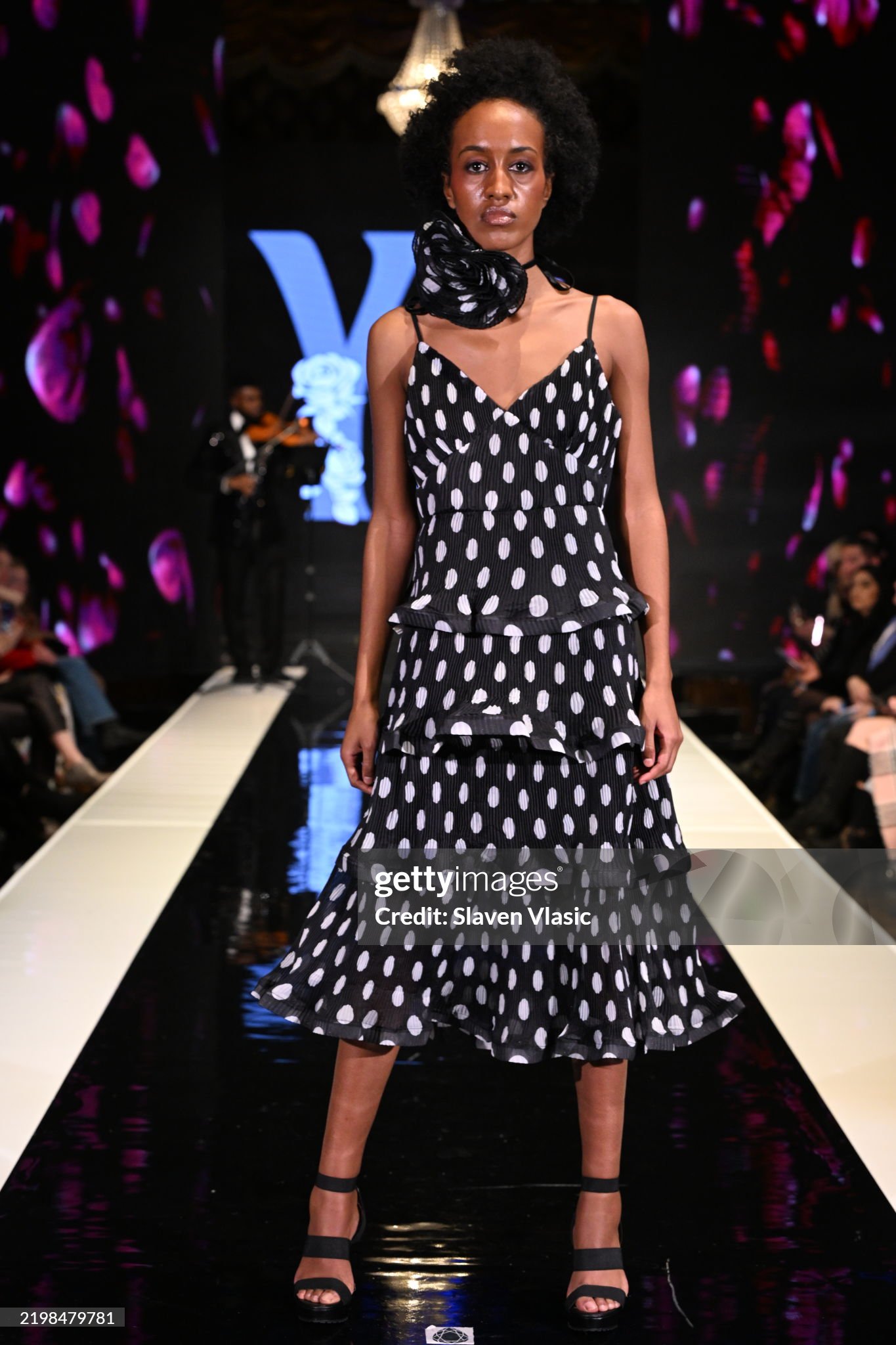 HiTechMODA Productions NYFW Season 13 - Yesi Rose Fashion NEW YORK, NEW YORK - FEBRUARY 08: Violinist Dr. Edward W. Hardy performs on stage while a model walks the runway wearing Yesi Rose Fashion du