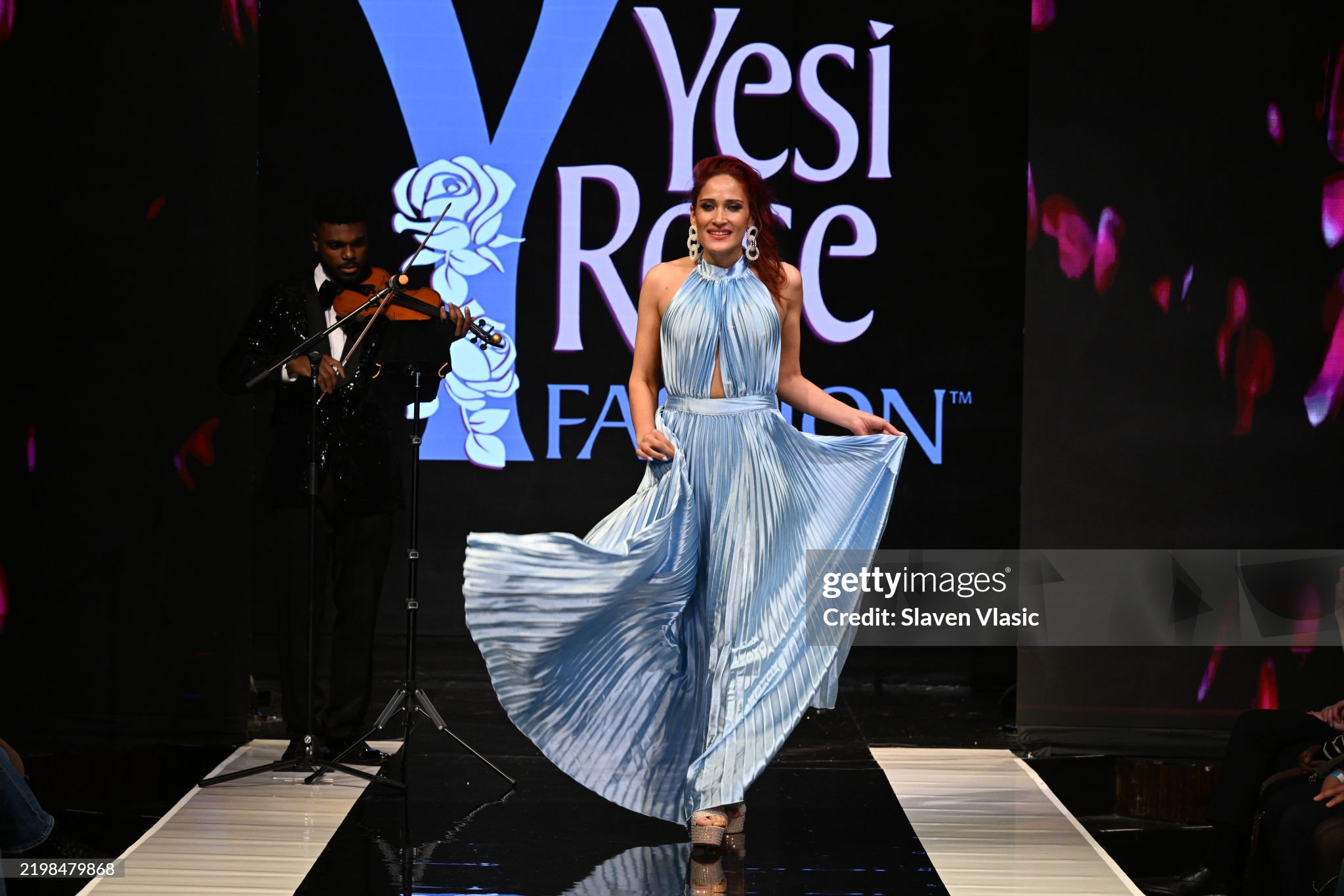 HiTechMODA Productions NYFW Season 13 - Yesi Rose Fashion NEW YORK, NEW YORK - FEBRUARY 08: Violinist Dr. Edward W. Hardy performs on stage while a model walks the runway wearing Yesi Rose Fashion du HiTechMODA Productions NYFW Season 13 - Yesi Rose Fashion NEW YORK, NEW YORK - FEBRUARY 08: Violinist Dr. Edward W. Hardy performs on stage while a model walks the runway wearing Yesi Rose Fashion du