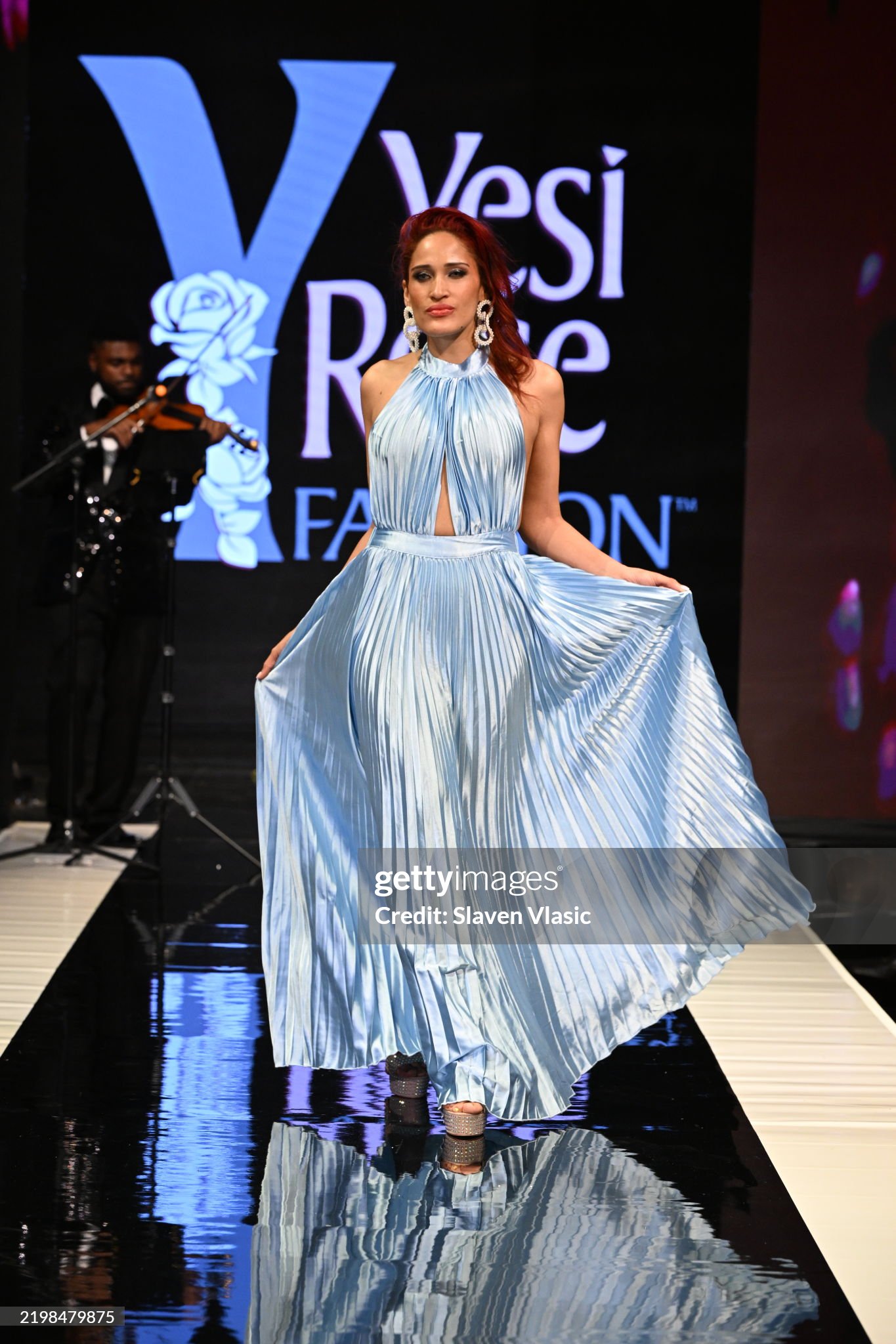 HiTechMODA Productions NYFW Season 13 - Yesi Rose Fashion NEW YORK, NEW YORK - FEBRUARY 08: Violinist Dr. Edward W. Hardy performs on stage while a model walks the runway wearing Yesi Rose Fashion du HiTechMODA Productions NYFW Season 13 - Yesi Rose Fashion NEW YORK, NEW YORK - FEBRUARY 08: Violinist Dr. Edward W. Hardy performs on stage while a model walks the runway wearing Yesi Rose Fashion du