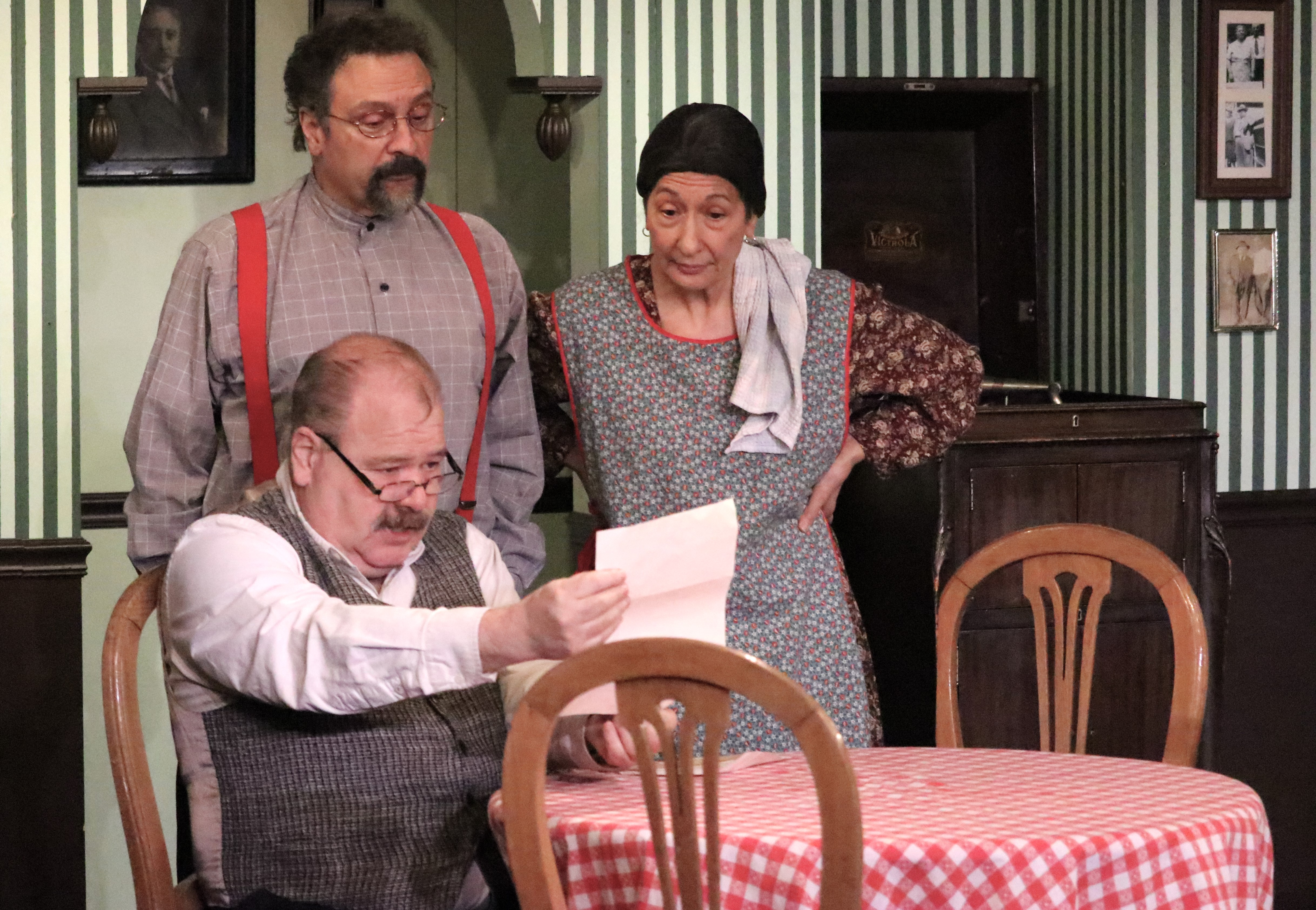 Angelo Baccolini reads a special letter to Piccino and Lucia Morello. Played by Randy Bucknoff, Lou Ursone and Janice Pasqua, respectively.