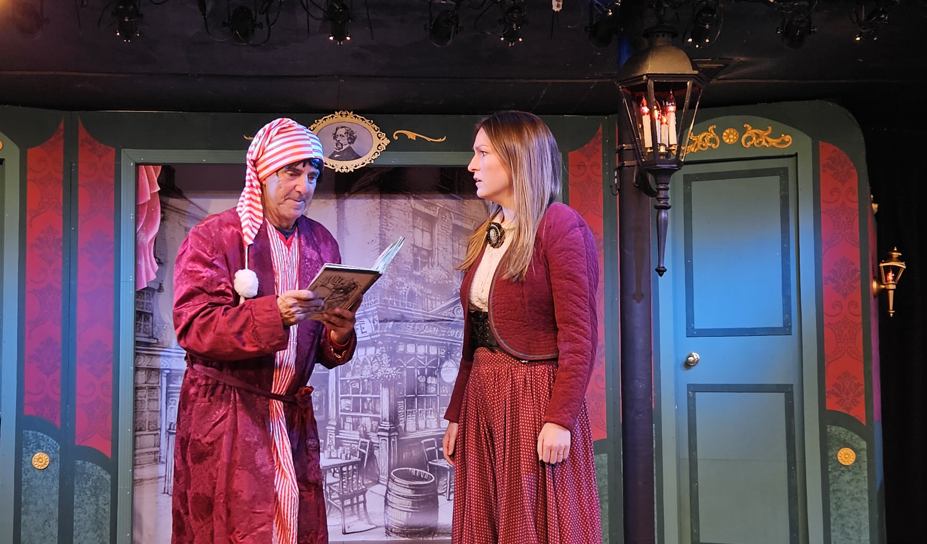 Ebenezer Scrooge and Bobbi Ann Cratchit discuss the merits of Charles Dickens'' book in THE THREE SCROOGES at Curtain Call...a madcap musical romp playing in The Dressing Room Theatre. (Michael Pela