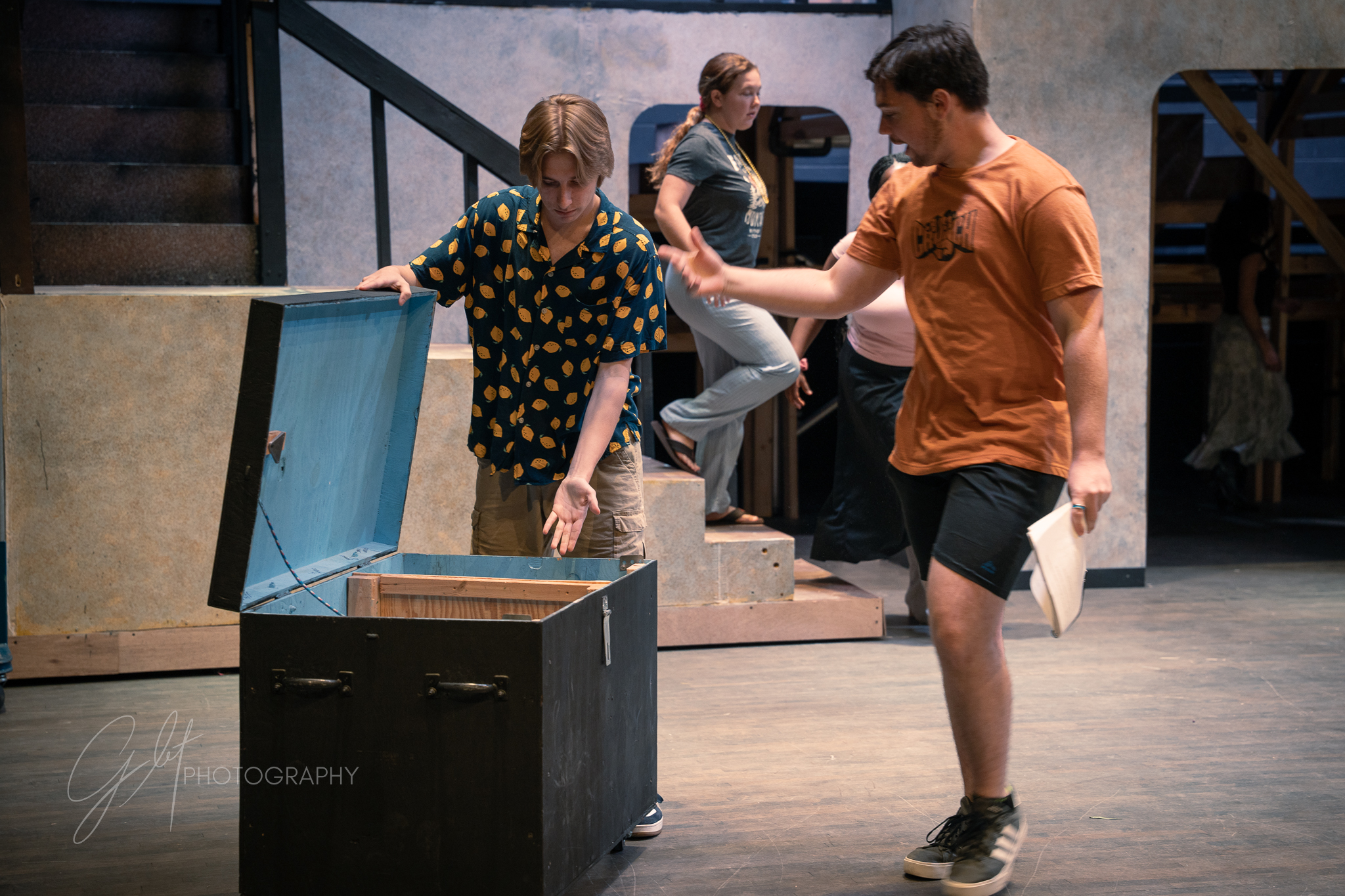 Gavin Hays (General Howell, Ensemble) shows props in a trunk to Christina Mageloff (Ralph - Stage Manager) during rehearsal