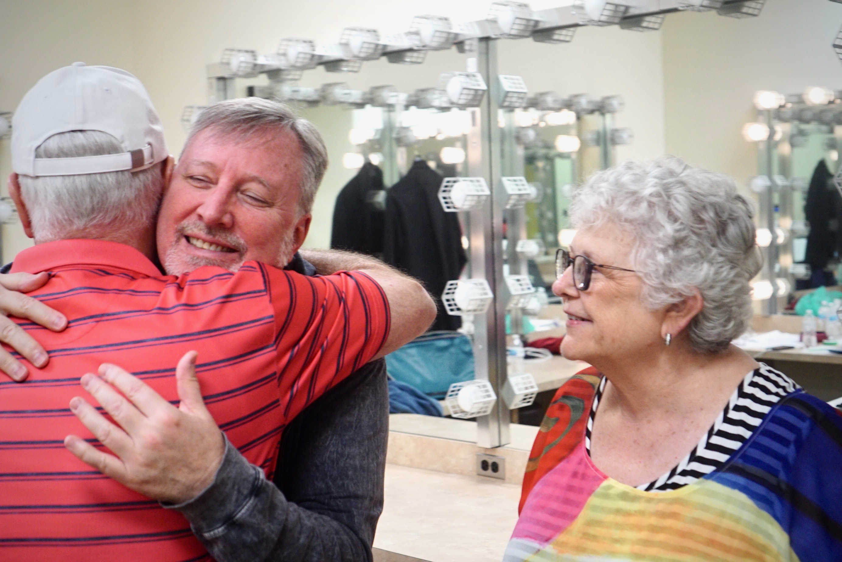 Camp director John McDaniel greets Jerry and Junie Chenoweth. Photo Credit: Merrill Mitchell