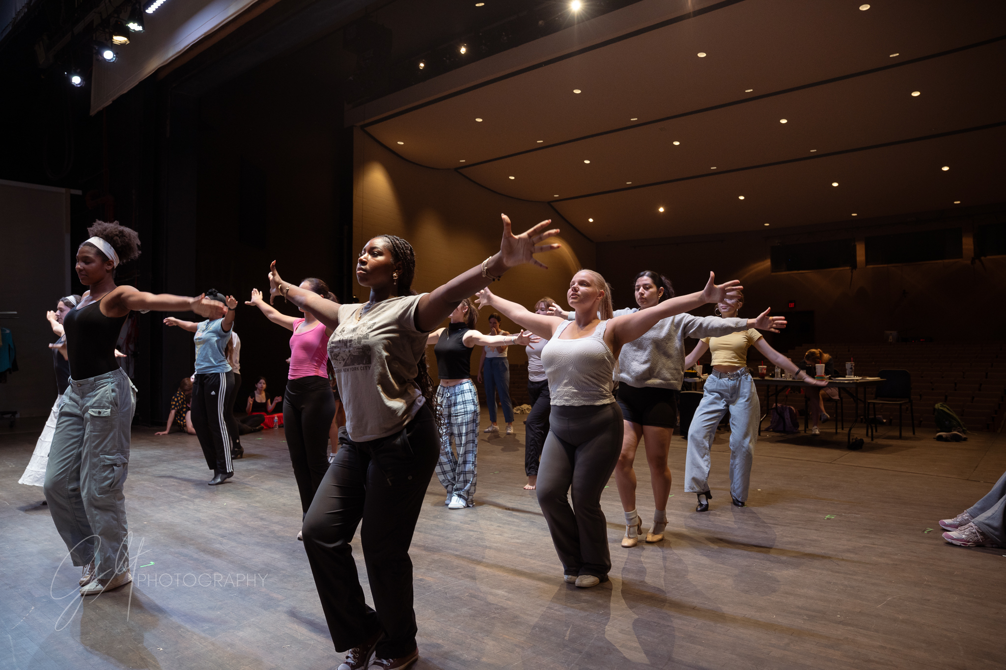Dancers pose facing upstage during rehearsal