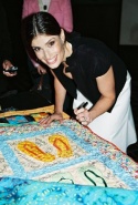 Idina Menzel signing a quilt to be auctioned off for the victims of Hurricane Katrina Photo