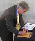 Henry Winkler autographing 'Fonzie' memorabilia for the charity tables Photo