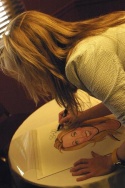 Sherie signs her caricature Photo