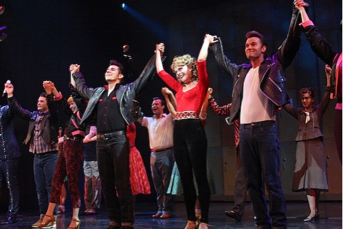 Derek Keeling and Ashley Spencer with the cast of Grease Photo