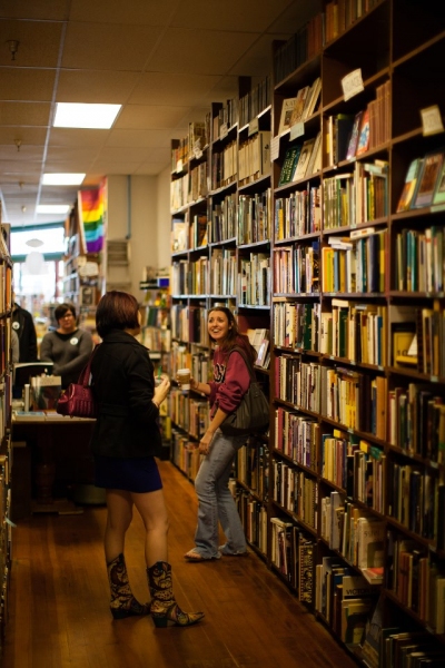 Audiences watch Whitney Shay as Chris and Kathryn Byrd as Alex among the stacks of bo Photo