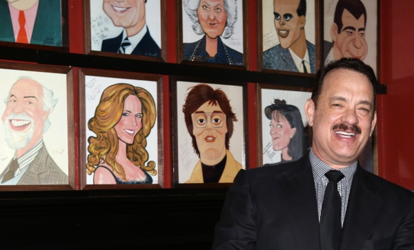Tom Hanks with wife Rita Wilson caricature behind him Photo