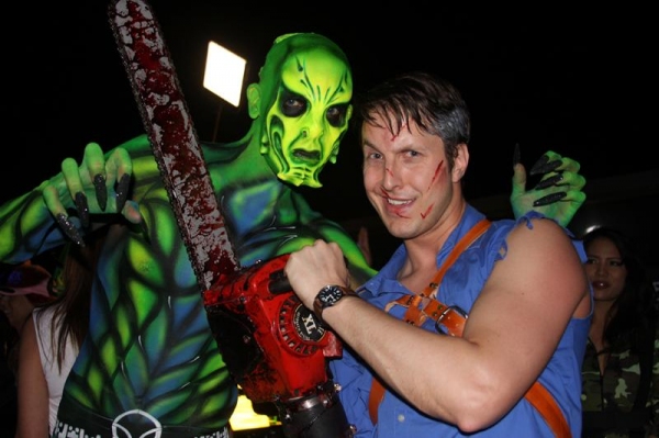 Ash (Ben Stobber) from EVIL DEAD poses with one of the airbrushed models on the pool  Photo