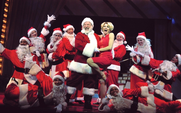 Deb Wims, center, finds the real Santa on a stage filled with imposters during the so Photo