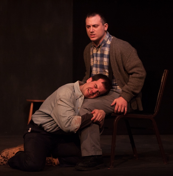 Katurian (Tom Mazzarella, kneeling) seeks comfort after his interrogation from his br Photo