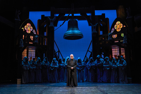 Dom Claude Frollo (Tom Ford*) is an imposing figure before his congregation with the  Photo