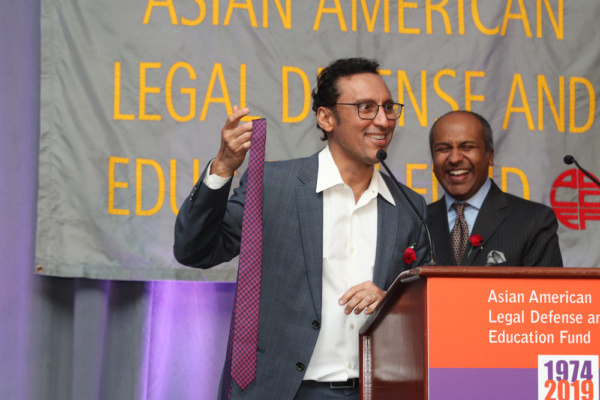 Aasif Mandvi donates his tie for AALDEF''s live auction; with emcee Sree Sreenivasan Photo