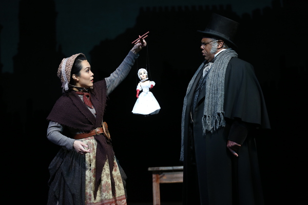 Justine “Icy” Moral as Doll Vendor and Craig Wallace as Ebenezer Scrooge Photo