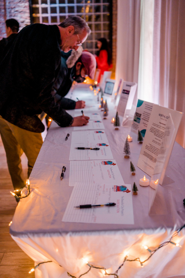 Audience Members sign up for the Silent Auction items, featuring tickets to local Chi Photo